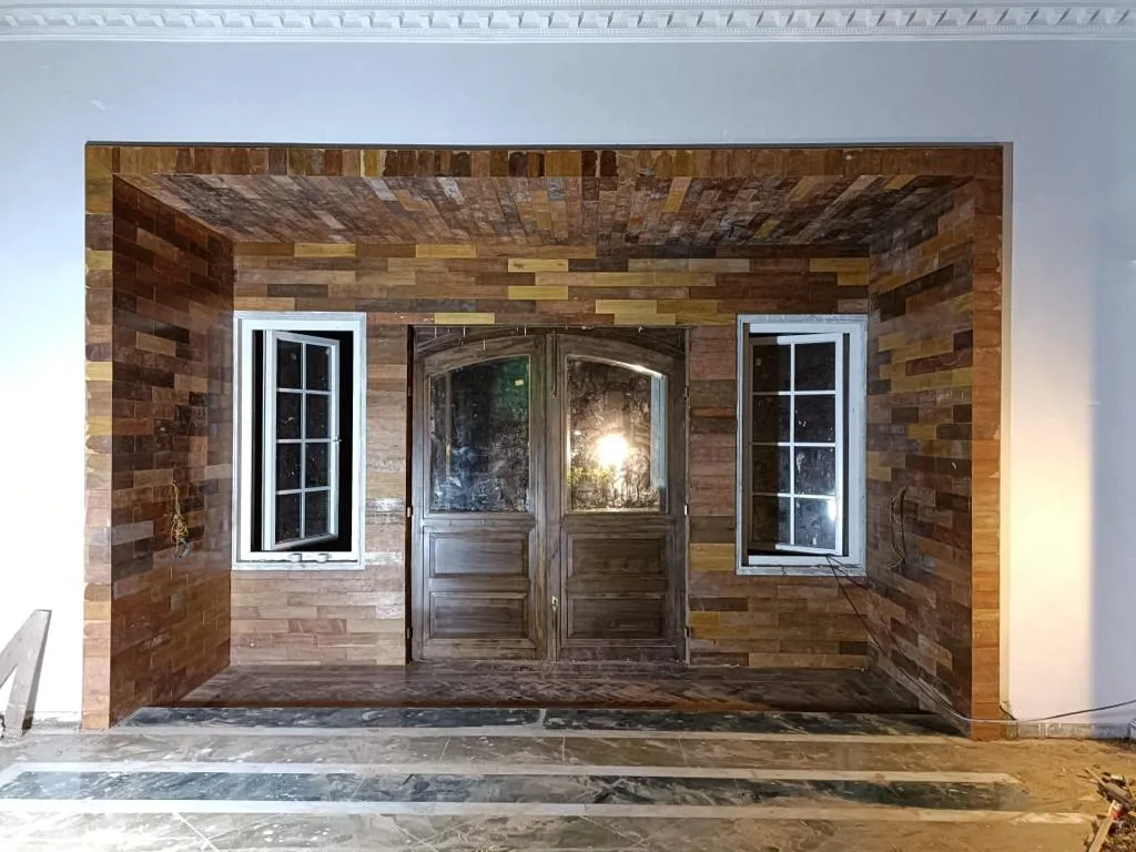 Commercial Interiors — Entrance with wooden wall cladding and carved doors