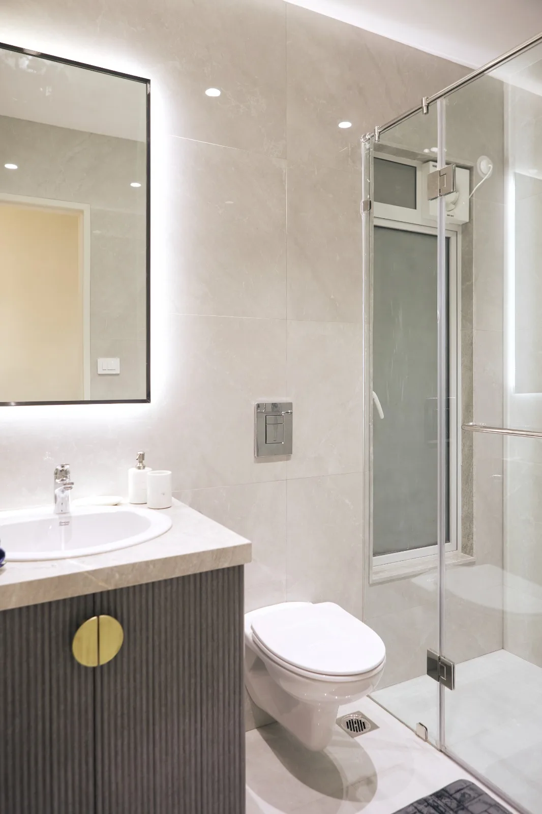 Finished bathroom with a shower enclosure, tiled walls and floor drain